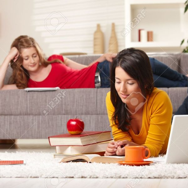 6373876-teenage-girls-studying-at-home-in-living-room-lying-on-sofa-and-floor-with-books-and-laptop-